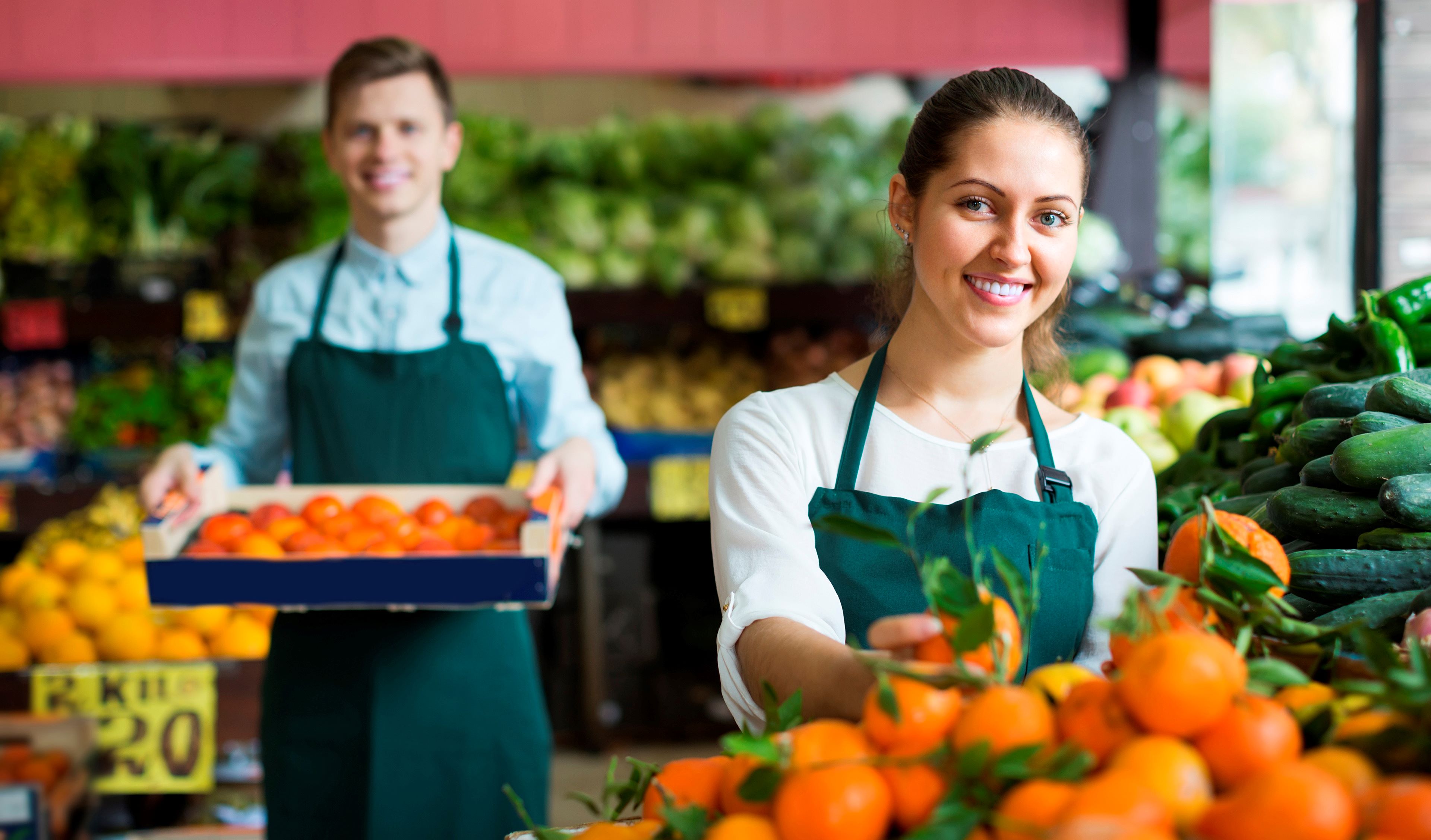Image of retail staff in store with a fresh produce display 