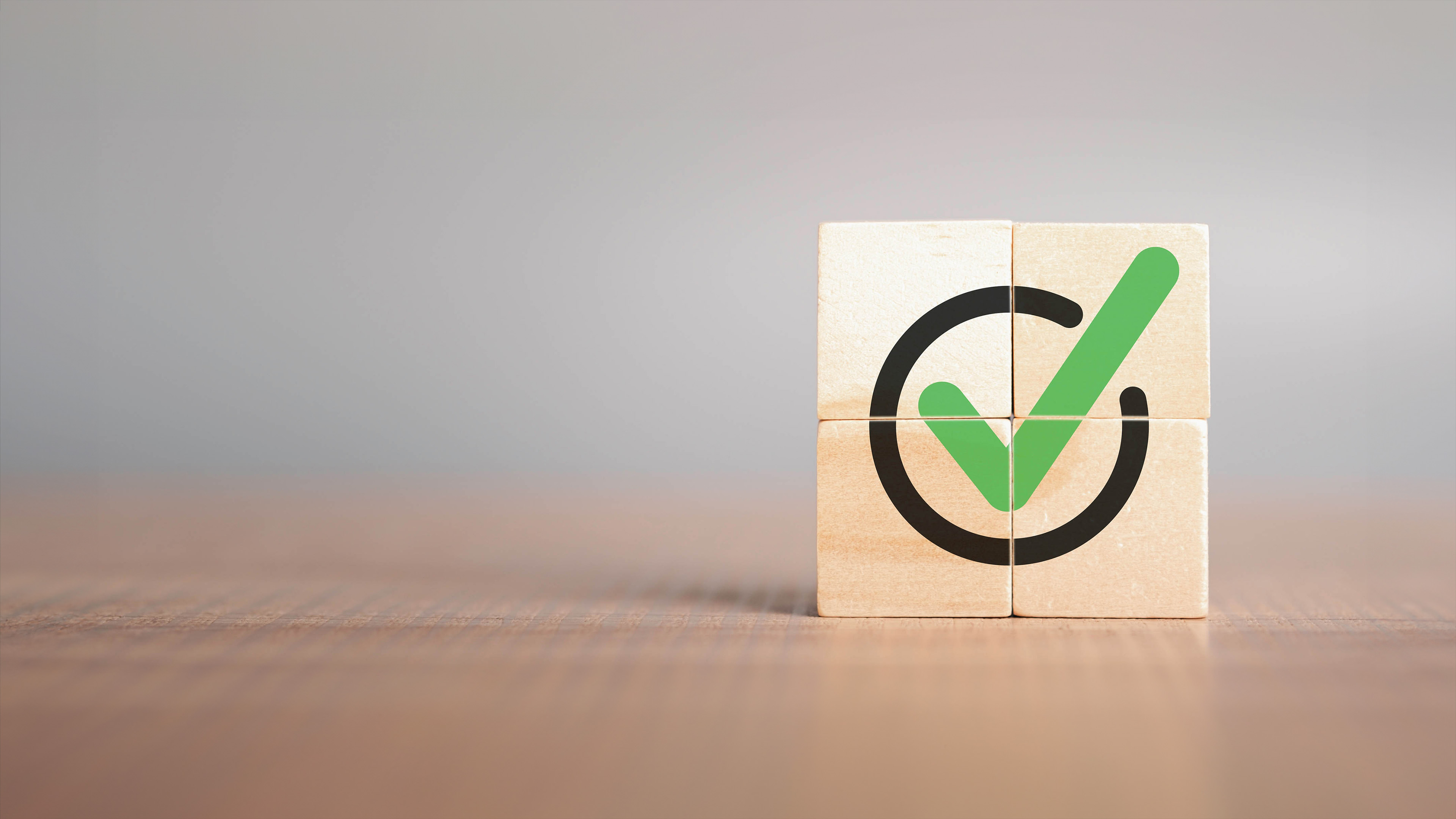 Image of four wooden blocks assembled to form a check mark icon 